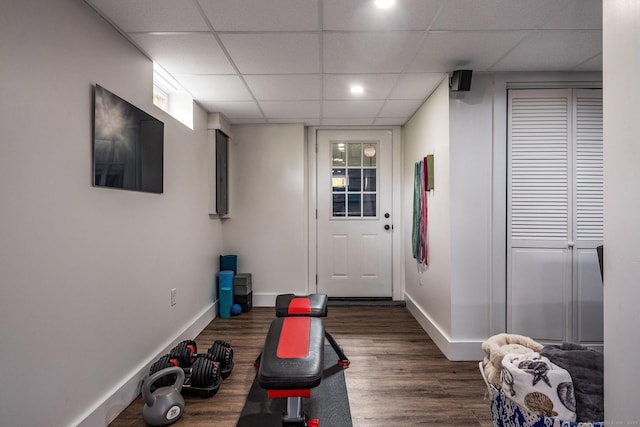 workout room with baseboards, dark wood finished floors, and a drop ceiling