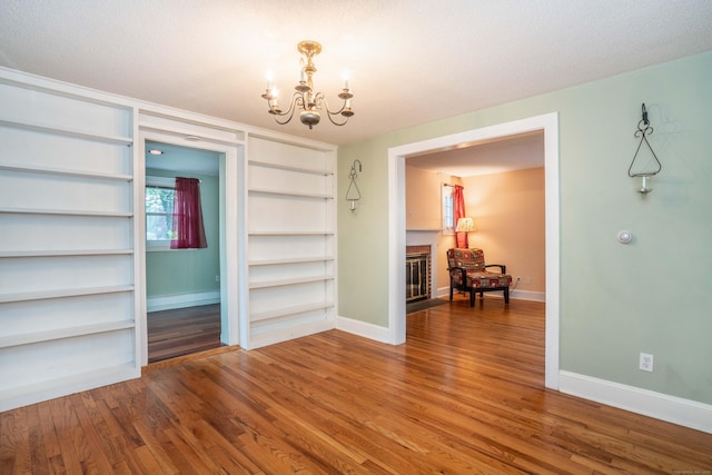 20 Fairview St, Simsbury, CT 06070 - unfurnished dining area featuring a notable chandelier, a fireplace with flush hearth, baseboards, and wood finished floors