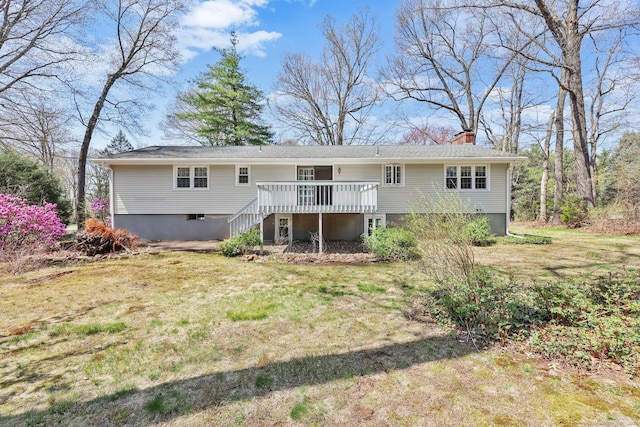 rear view of house featuring a lawn, stairway, a wooden deck, and a chimney