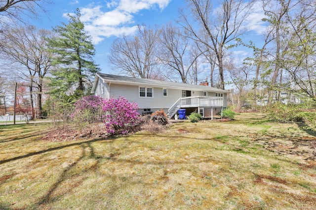 back of property with stairway, a deck, a yard, and a chimney