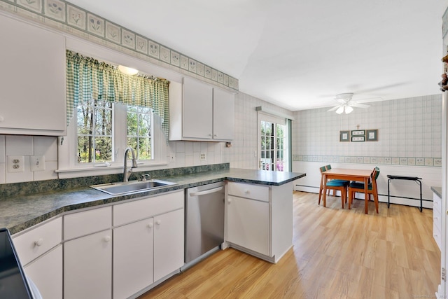 kitchen with a sink, dishwasher, white cabinets, and wallpapered walls