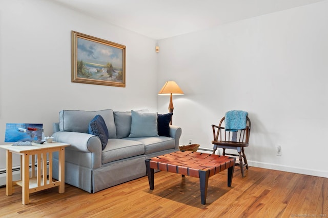 living room featuring baseboards, a baseboard radiator, and light wood-type flooring