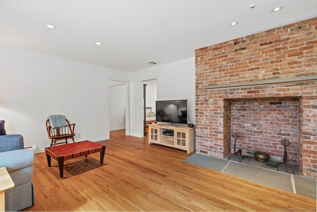 living area with baseboards, recessed lighting, wood finished floors, and visible vents