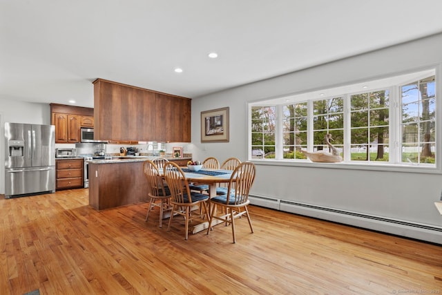 dining area featuring light wood-style floors, baseboard heating, and recessed lighting
