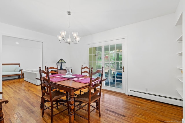 dining room featuring light wood-style flooring, a notable chandelier, and baseboard heating