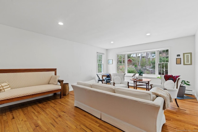 living room featuring recessed lighting, a baseboard heating unit, and light wood finished floors