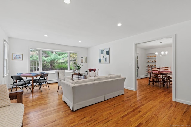 living area featuring a notable chandelier, light wood-style flooring, recessed lighting, baseboards, and a baseboard radiator