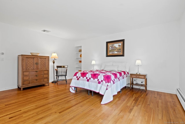 bedroom with baseboards, baseboard heating, light wood-style flooring, and visible vents