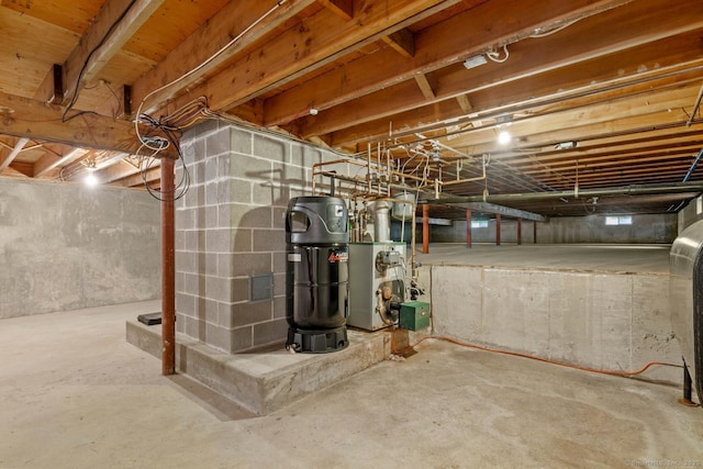 unfinished basement with water heater and a heating unit