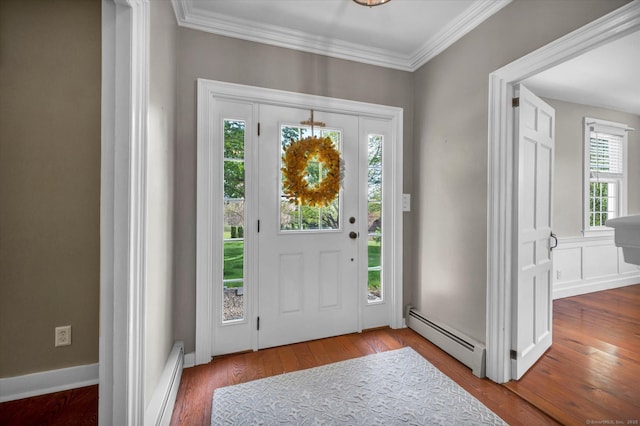 entrance foyer with ornamental molding, a baseboard heating unit, and hardwood / wood-style flooring