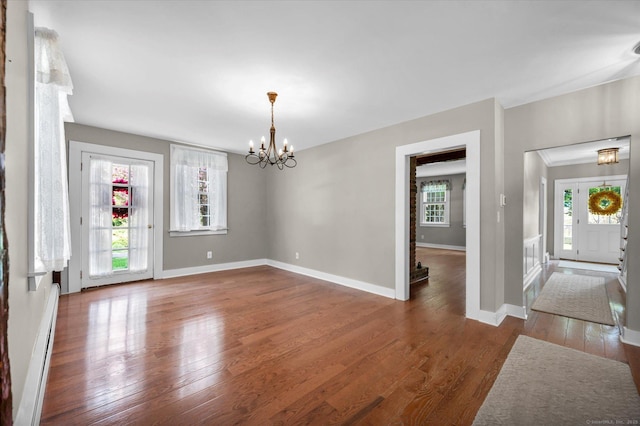 interior space with an inviting chandelier, baseboards, wood finished floors, and baseboard heating