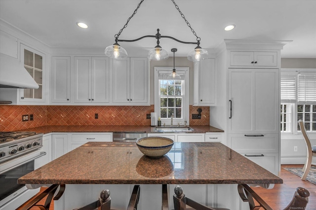 kitchen with appliances with stainless steel finishes, white cabinets, and a breakfast bar