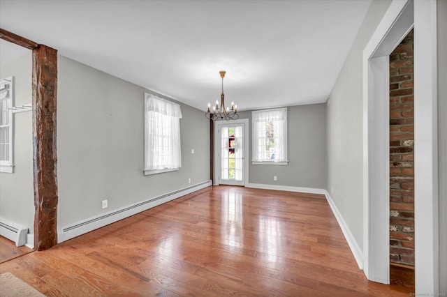 unfurnished dining area with a baseboard heating unit, a chandelier, hardwood / wood-style floors, and a baseboard radiator