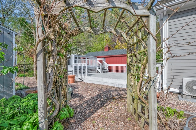 view of gate with a wooden deck and ac unit