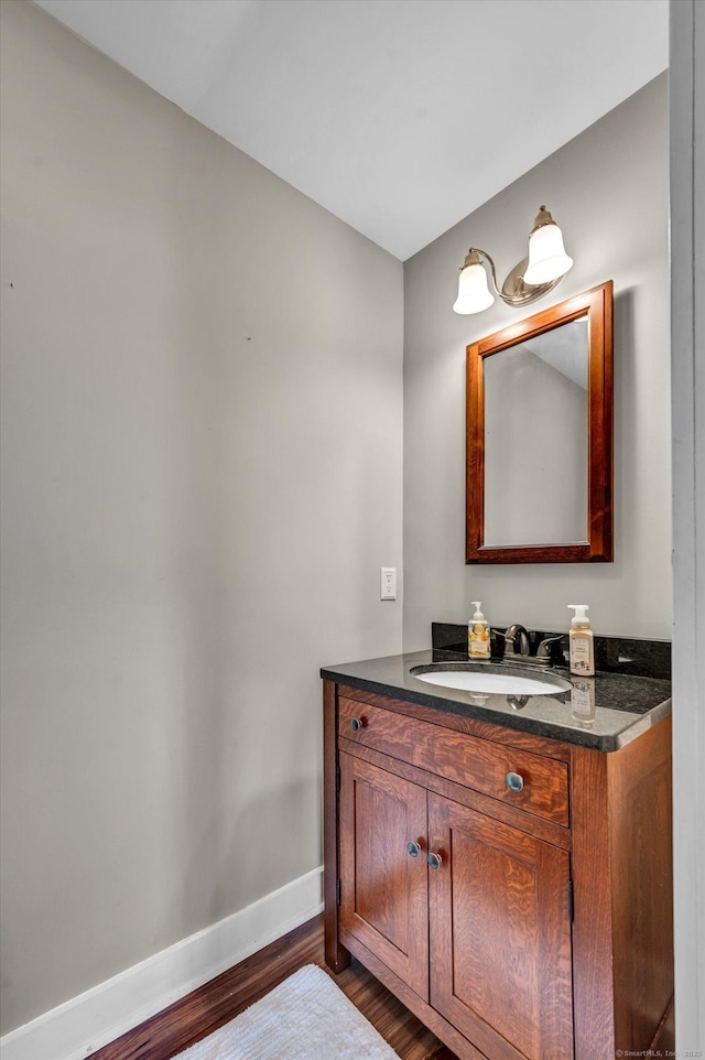 bathroom featuring baseboards, wood finished floors, and vanity