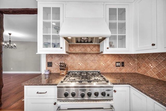 kitchen featuring an inviting chandelier, white cabinetry, baseboards, decorative backsplash, and island exhaust hood