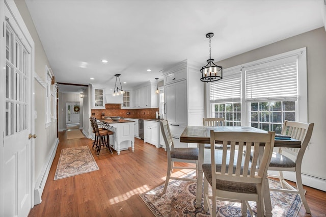 dining room with an inviting chandelier, baseboards, recessed lighting, and light wood-style flooring