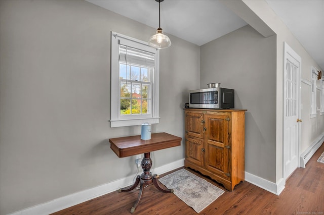 interior space featuring baseboards, wood finished floors, and a baseboard radiator
