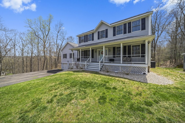 view of front facade with a porch, a front lawn, driveway, and central air condition unit
