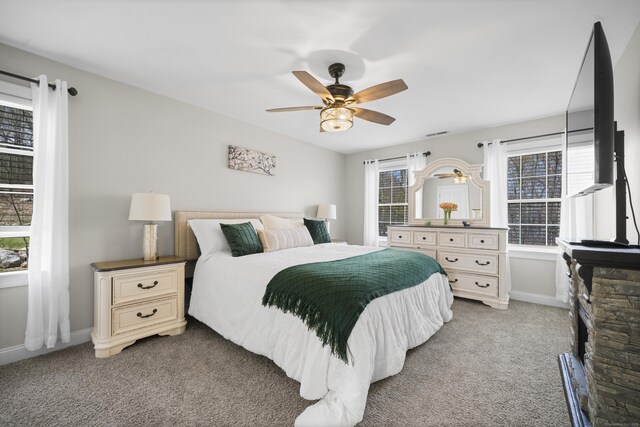 bedroom with light colored carpet, a ceiling fan, and baseboards