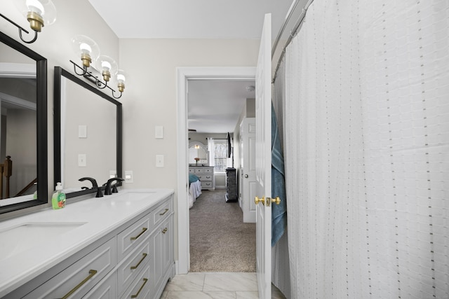 bathroom with a shower with shower curtain, double vanity, a sink, and ensuite bathroom