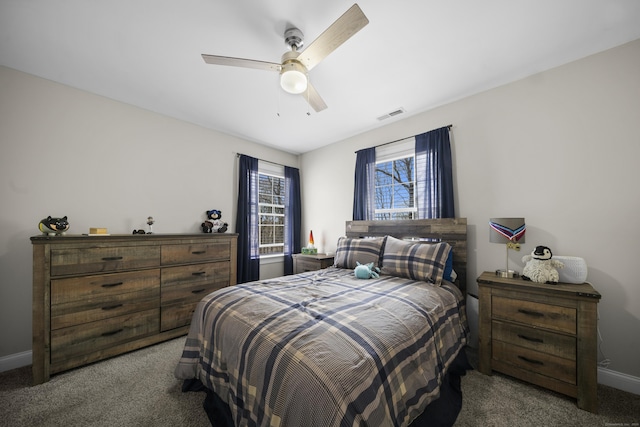 carpeted bedroom featuring baseboards, visible vents, and a ceiling fan