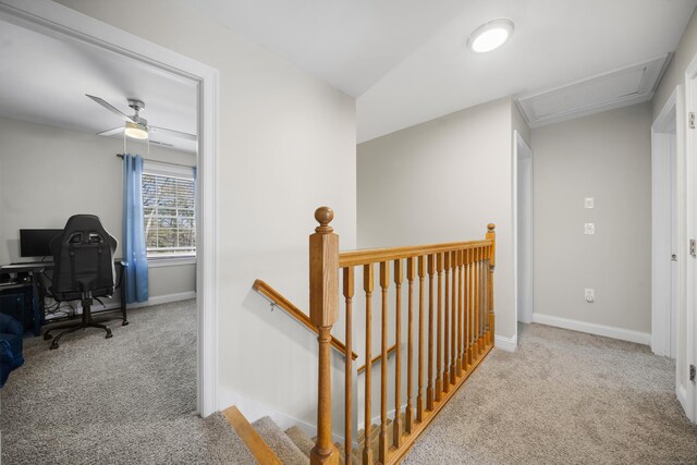 hallway featuring an upstairs landing, baseboards, and carpet floors