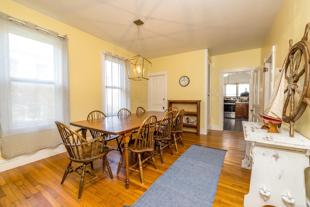 16 Pearl St, Groton, CT 06355 - dining space with wood-type flooring, baseboards, a notable chandelier, and plenty of natural light