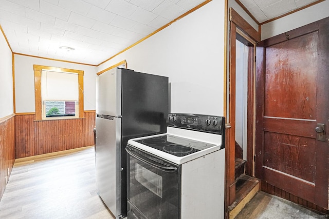 kitchen featuring range with electric stovetop, ornamental molding, light wood finished floors, a wainscoted wall, and freestanding refrigerator