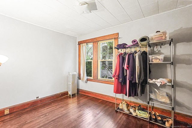 spare room with radiator, wood finished floors, and baseboards