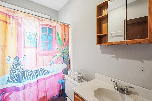 bathroom with vanity, curtained shower, and toilet
