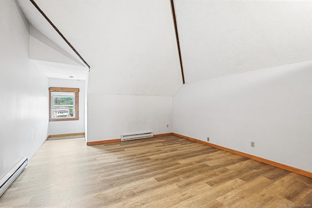 bonus room featuring a baseboard heating unit, vaulted ceiling, light wood-style floors, and baseboards