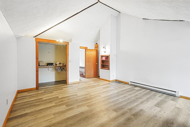 unfurnished living room with baseboard heating, wood finished floors, baseboards, a textured ceiling, and high vaulted ceiling