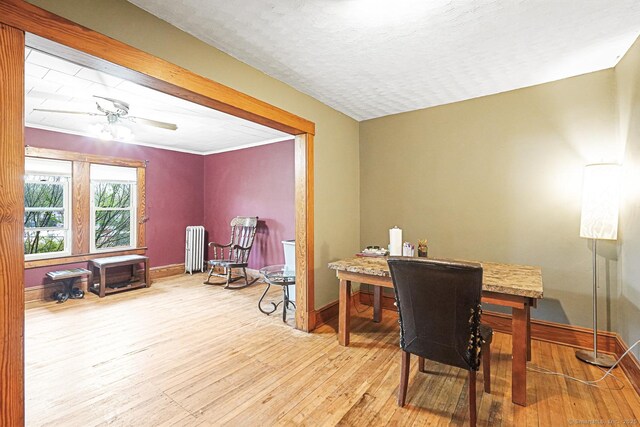 home office with radiator heating unit, hardwood / wood-style flooring, baseboards, and a ceiling fan