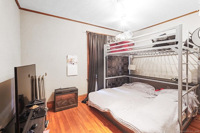 bedroom featuring ornamental molding and hardwood / wood-style floors