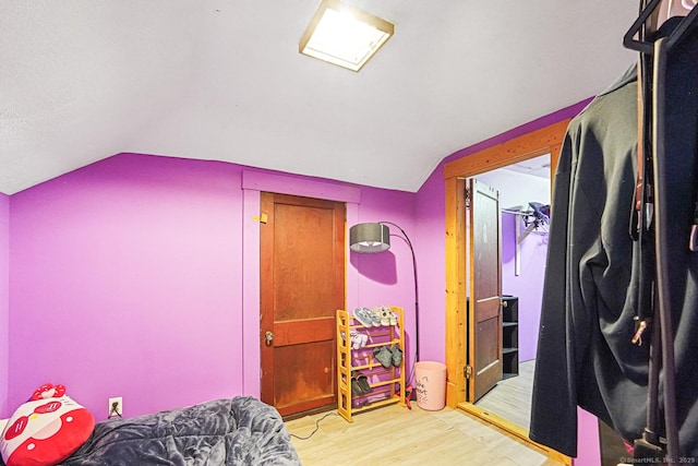 bedroom with lofted ceiling and wood finished floors