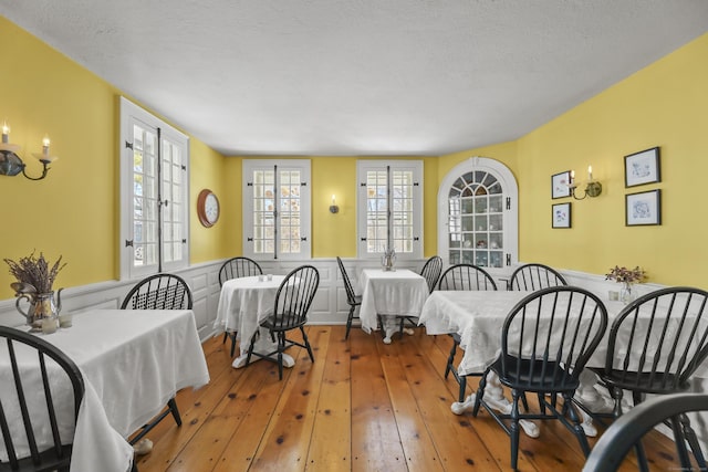 802 State Rd, Richmond, MA 01254 - dining area featuring hardwood / wood-style floors, wainscoting, and a textured ceiling