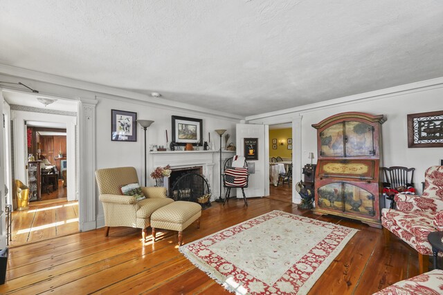 802 State Rd, Richmond, MA 01254 - living area featuring hardwood / wood-style flooring, a fireplace, a textured ceiling, and ornamental molding