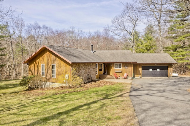 ranch-style house with roof with shingles, an attached garage, a front lawn, and driveway