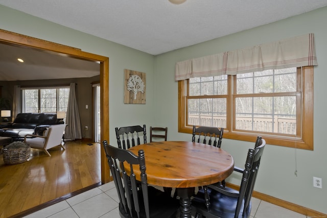 dining space with baseboards and light tile patterned flooring