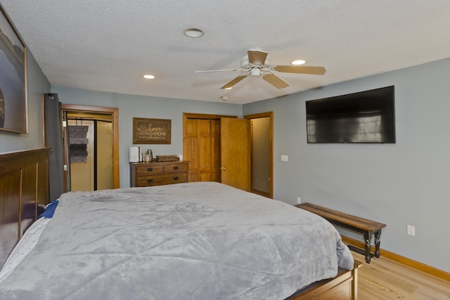 bedroom featuring a ceiling fan, recessed lighting, baseboards, two closets, and wood finished floors