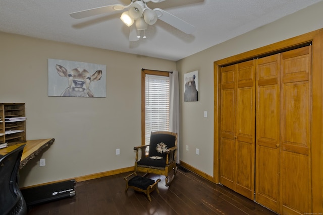 living area featuring baseboards, dark wood-style flooring, and ceiling fan