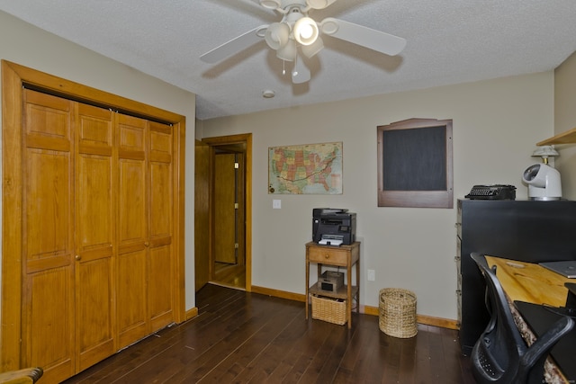 home office featuring a textured ceiling, baseboards, dark wood-style flooring, and a ceiling fan