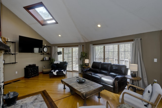 living area featuring wood finished floors, baseboards, vaulted ceiling with skylight, and recessed lighting