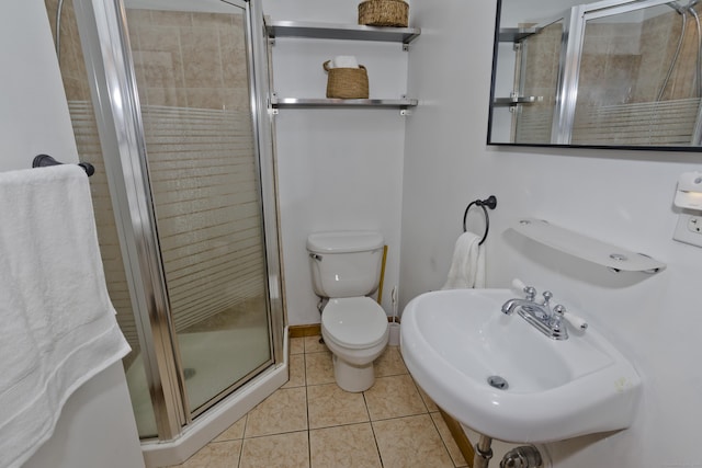 full bath featuring a stall shower, tile patterned flooring, toilet, and a sink