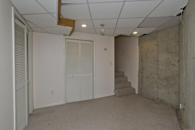 finished basement featuring carpet flooring, a paneled ceiling, stairway, and recessed lighting