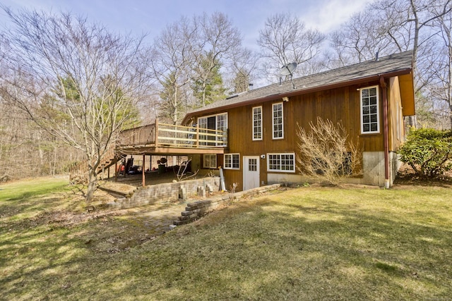 rear view of property with stairway, a deck, and a lawn