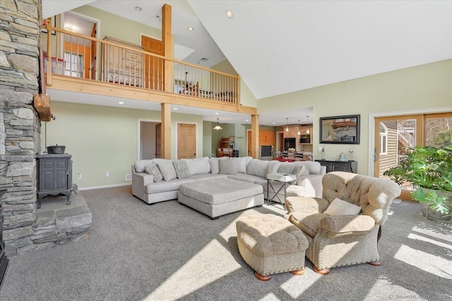 living area featuring a wood stove, recessed lighting, carpet flooring, high vaulted ceiling, and baseboards