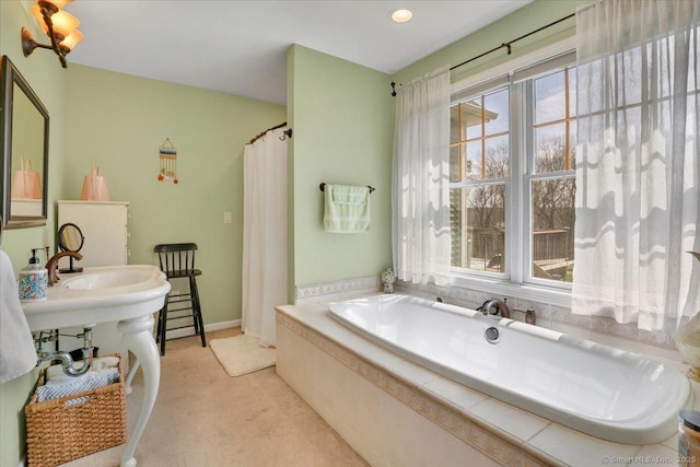 full bath with a garden tub and a healthy amount of sunlight