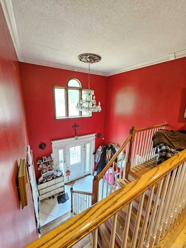935 Gaylord Mountain Rd, Hamden, CT 06518 - stairway featuring a textured ceiling, a chandelier, tile patterned flooring, ornamental molding, and a towering ceiling